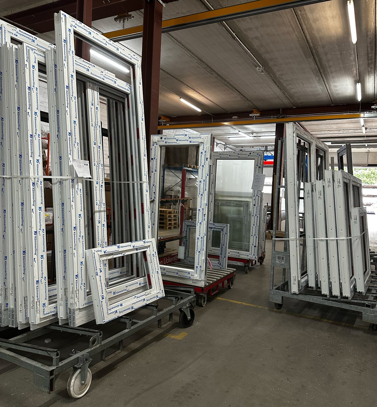 Das Bild zeigt fertig produzierte Fenster der ROLF Fensterbau GmbH, die in einer Halle gelagert werden.