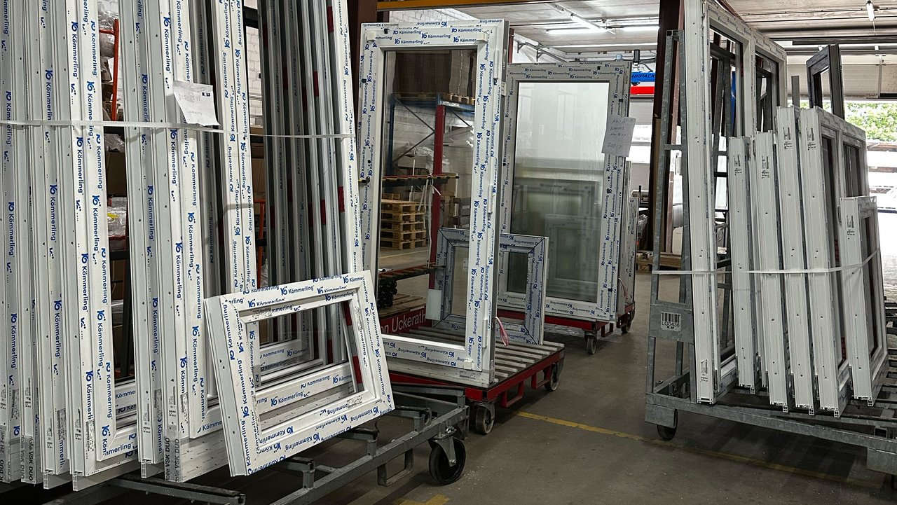Das Bild zeigt fertig produzierte Fenster der ROLF Fensterbau GmbH, die in einer Halle gelagert werden.